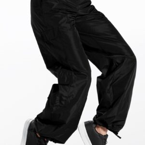 A person wearing Low Rise 4 Pocket Cargo Hip Hop Pants and black sneakers is shown in mid-motion against a white background. The cargo pants feature an elastic waistband and gathered cuffs at the ankles.