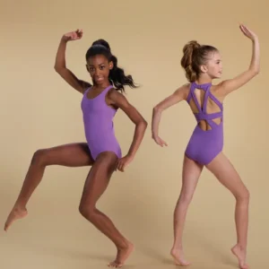 Two young girls barefoot in Strappy Cutout Halter Leotards pose against a beige background—one faces forward with arms bent and a raised leg, while the other stands sideways with arms up, displaying the leotard’s strappy back.