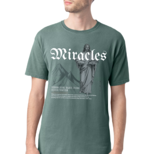 A man with long hair pulled back wears the "Miracles" T-Shirt, which features the word Miracles, an image of Jesus, mountains, and event details printed in white on the front.